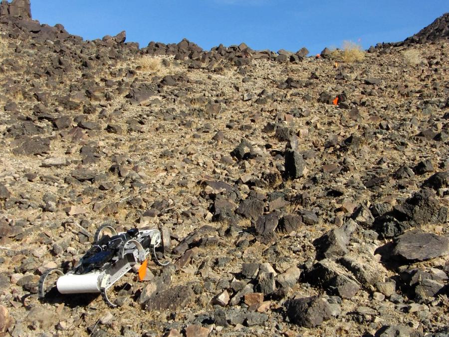 The robot navigates rocky, steep terrain.