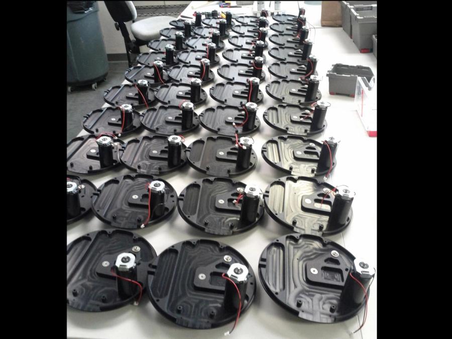 A table covered in black disks with electronics.