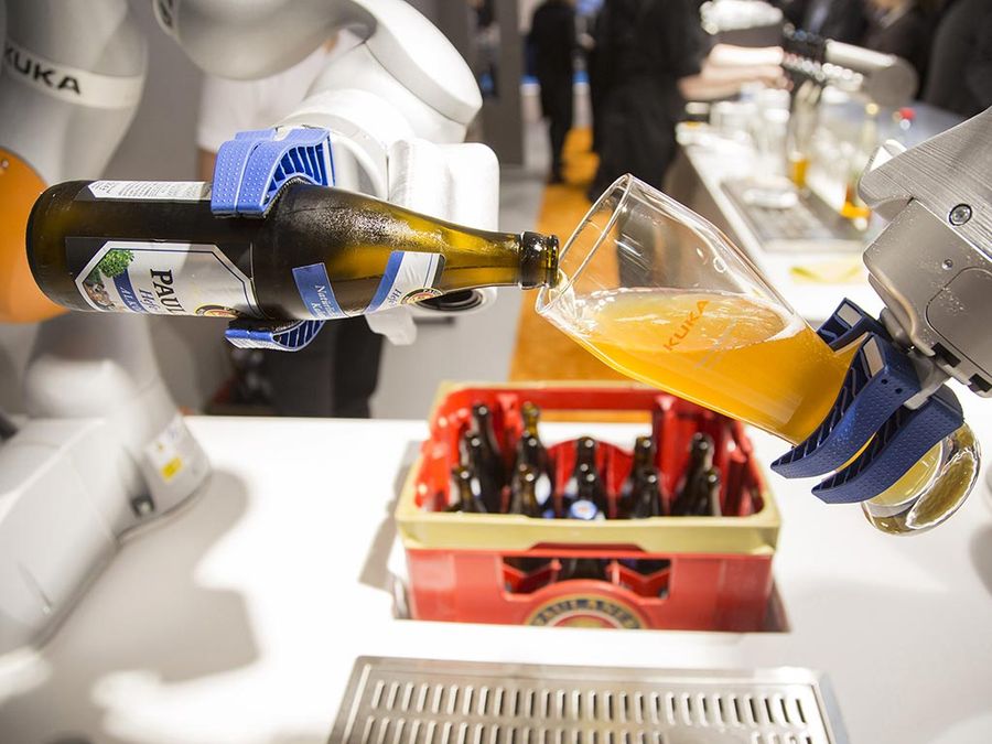 Close-up of blue gripper hands as they pour a beer into a glass.