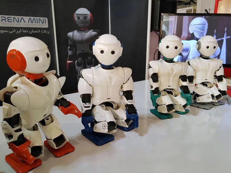 Four knee-high humanoid robots of different colors stand on a table.