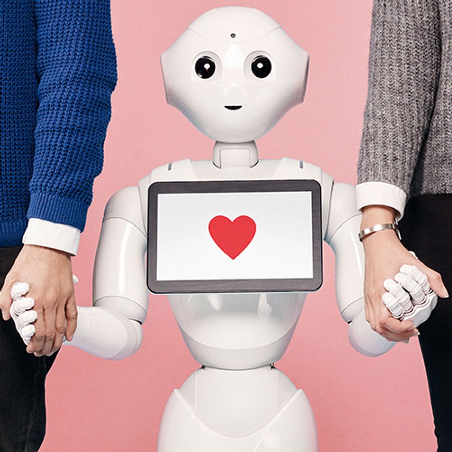 A friendly white robot with a heart displayed on its tablet holds hands with two larger adult humans.