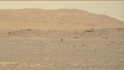 Ingenuity helicopter flying over the rocky surface of Mars.