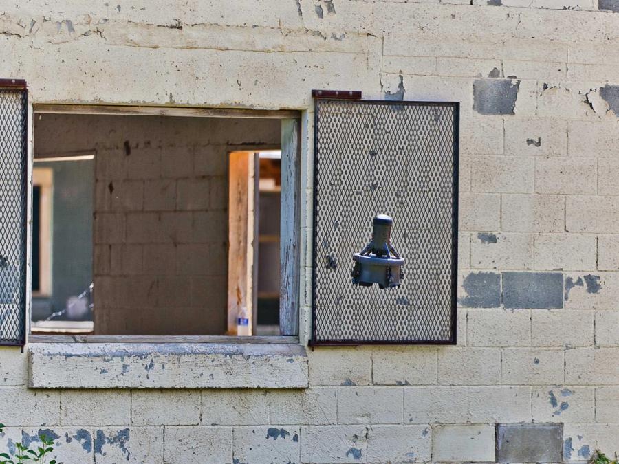 A small flying robot in front of an open window.