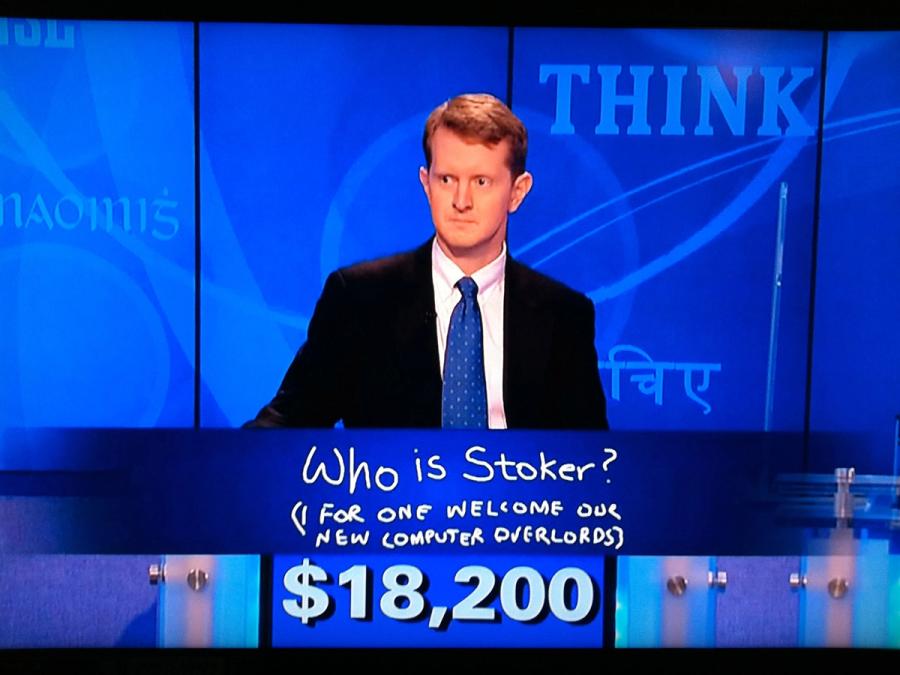 An inquisitive human man in a suit plays Jeopardy! He has $18,200 and has written "Who is Stocker? (I for one welcome our new computer overlords).