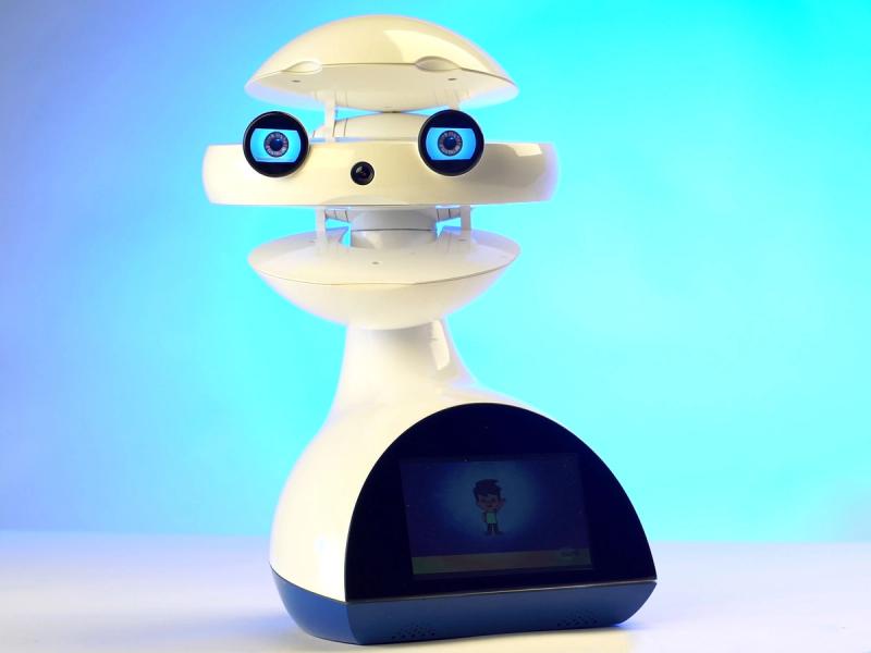 A beige robotic head consisting of three spherical segments and expressive eyes on a base with a display.