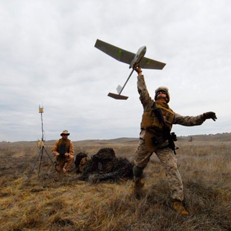 Soldier throwing a winged drone into the air.