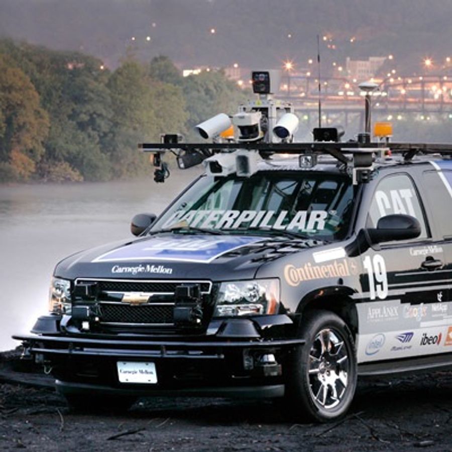 An SUV topped with a rack full of cameras and electronics.