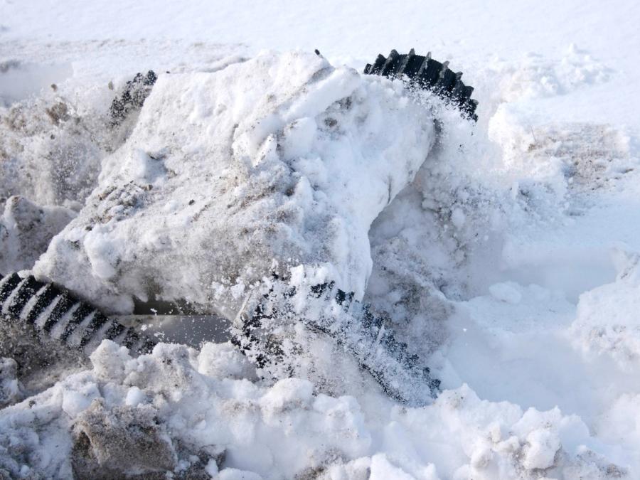 The robot partially covered in snow.