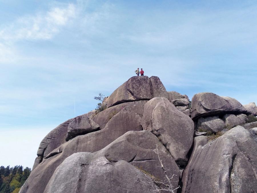 Drone photograph of two people at the top of a large structure of rocks.