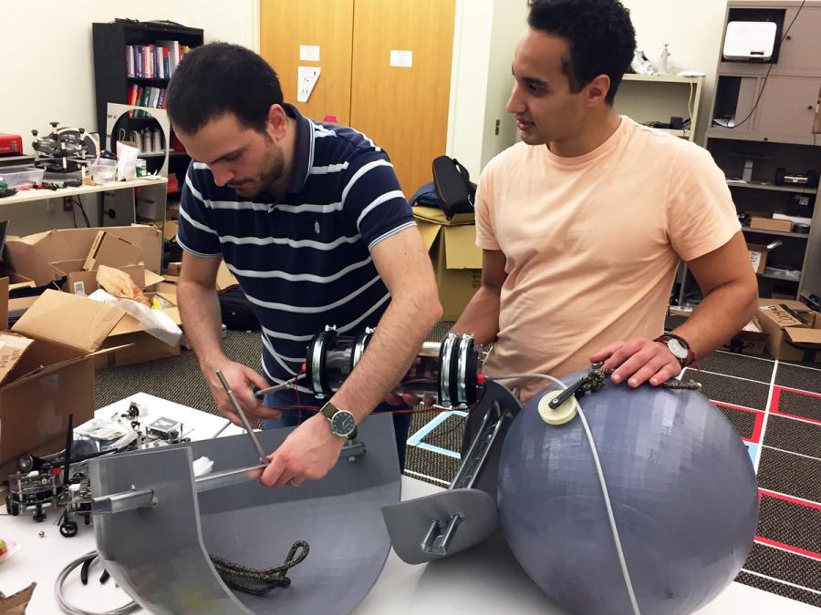 The people in a lab work on assembling the robot.