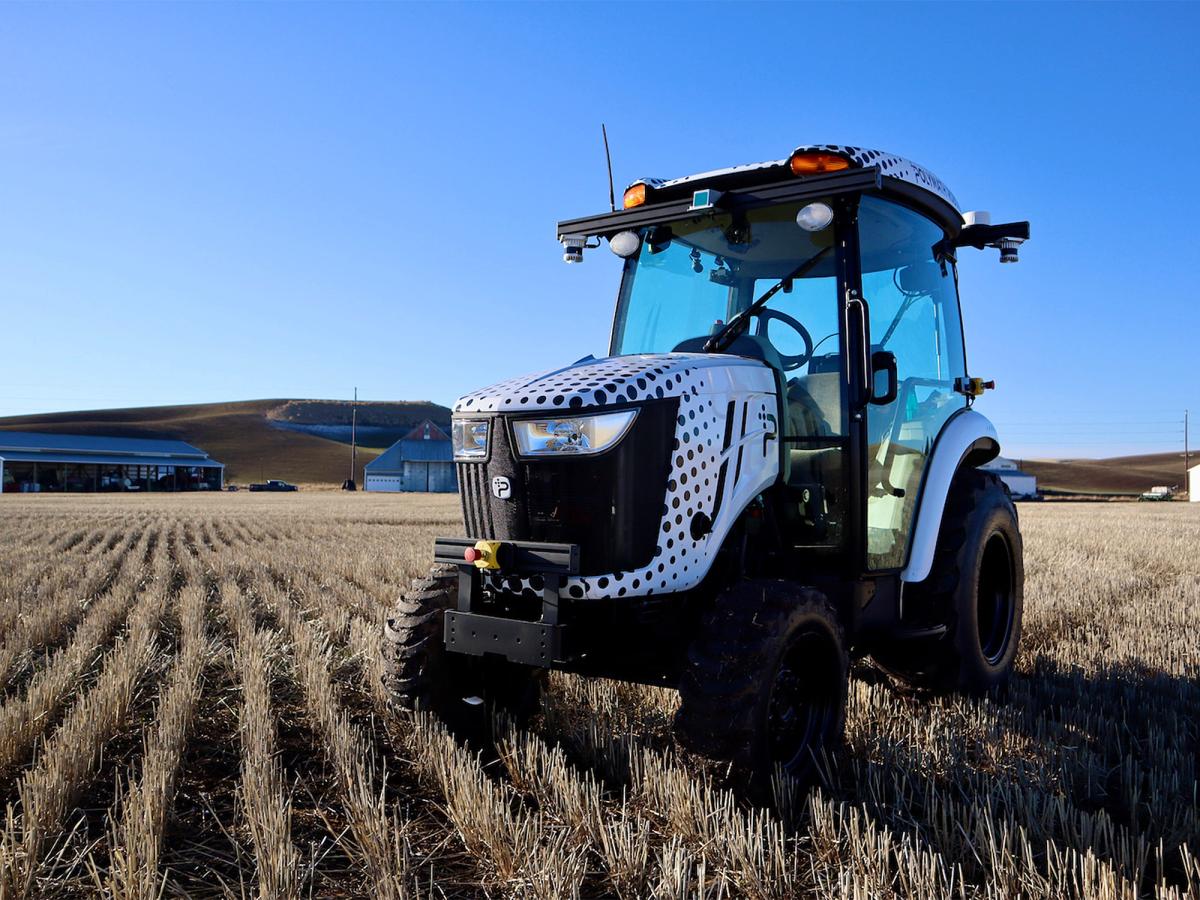 An empty Polymath Robotics autonomous tractor sits in a field.