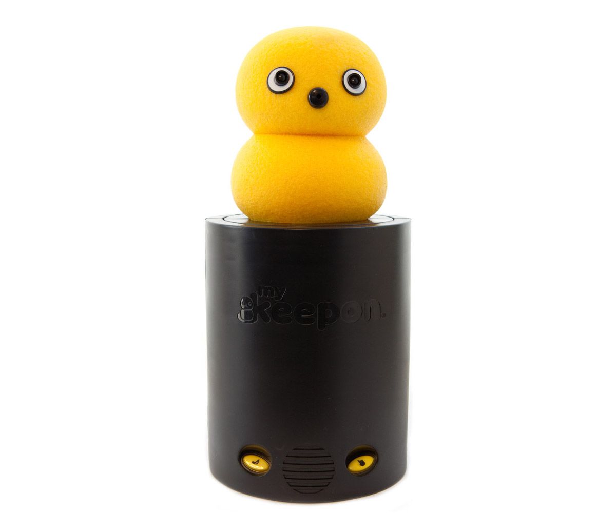 A robot that looks like two yellow balls squished together, with googly eyes and a button nose, bops around on a black stand.