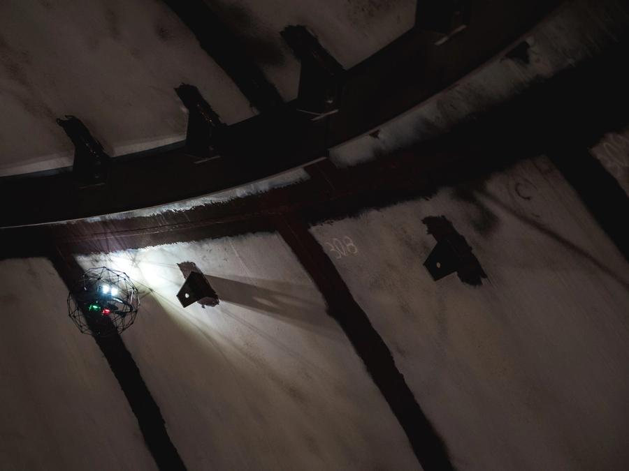 The drone flies inside an industrial tank.